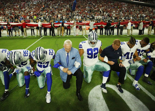 The Dallas Cowboys kneel during the national anthem before a game.