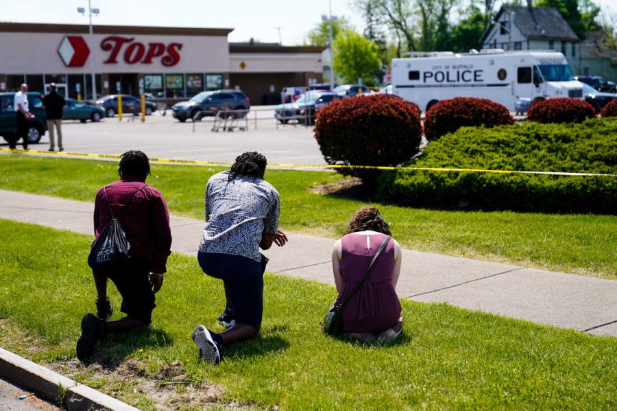 Onlookers pray outside the site of the Buffalo Massacre. (Source: Matt Rourke)