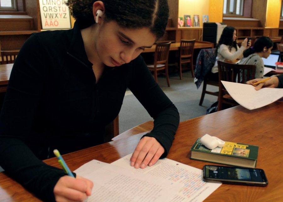 Cleo Barowsky (V) listens to music while doing homework. (Photo Credit: Lauren Dong (V))