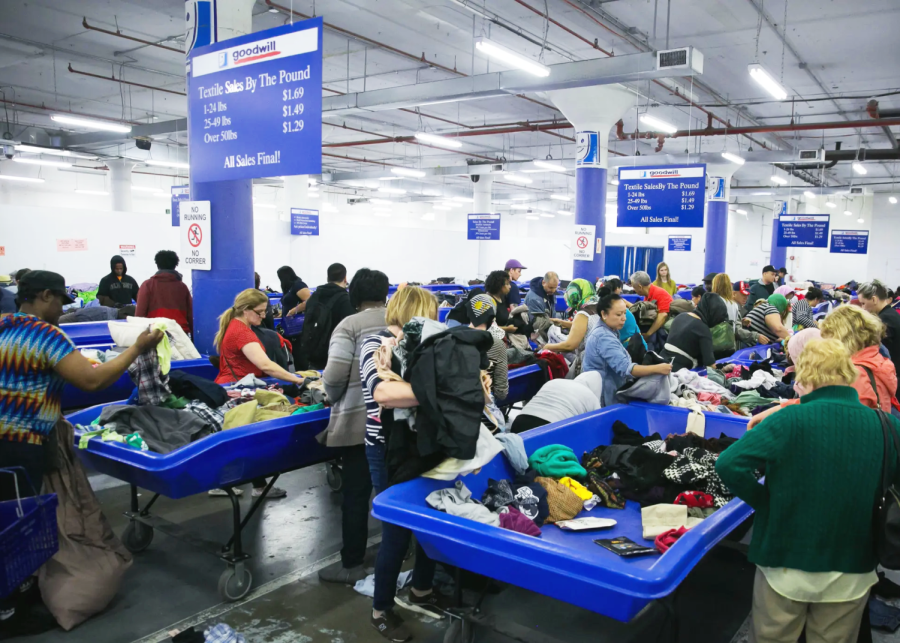 People dig through bins filled with clothes at Goodwill. (Source: Nicole Craine)