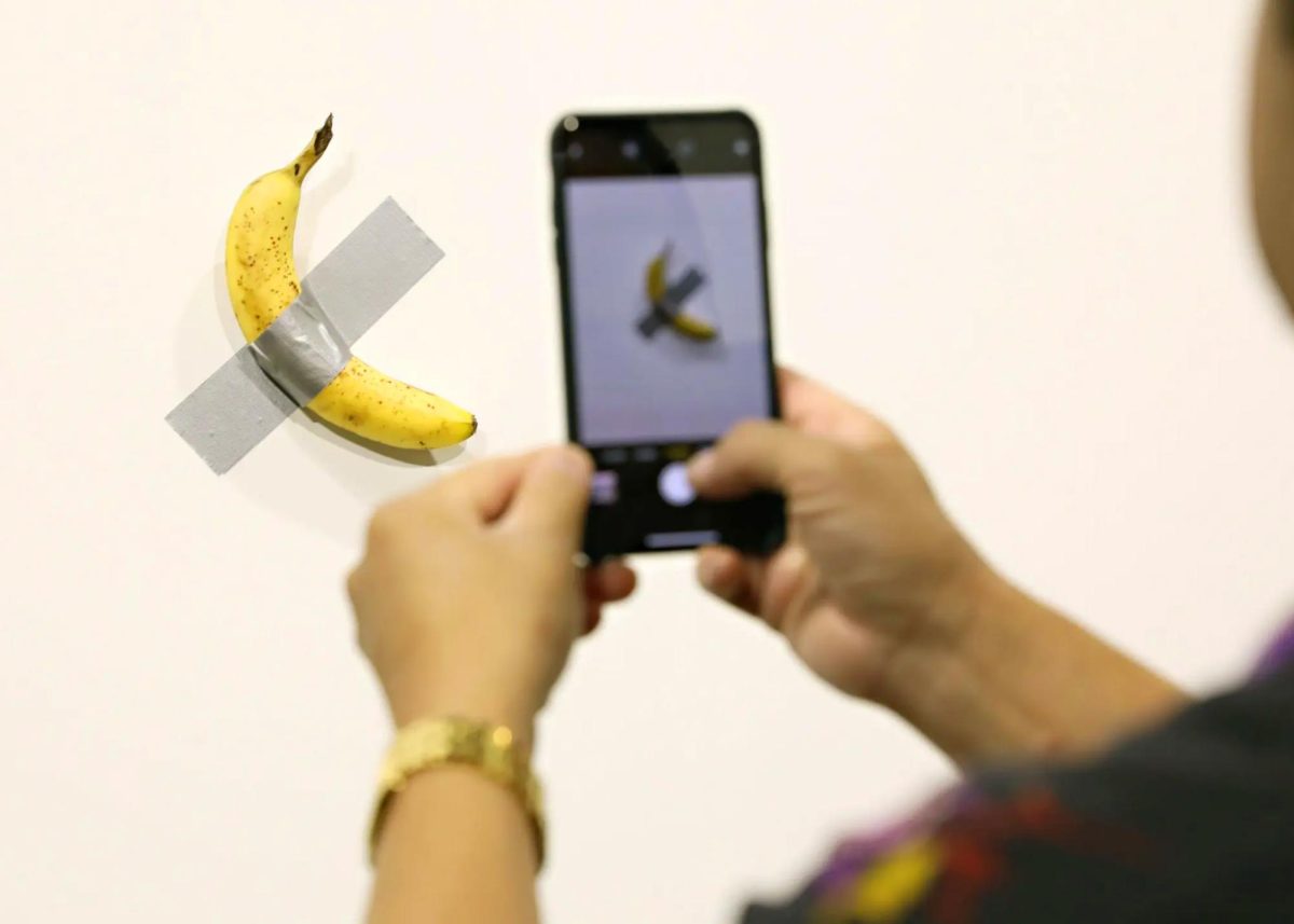 Viewers photograph Maurizio Cattelan’s Comedian, the viral banana duct-taped to a wall. (Source: Cindy Ord)