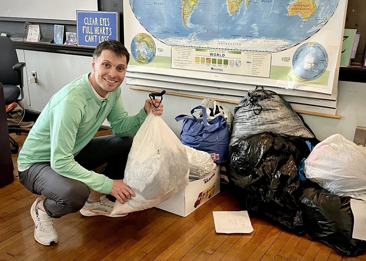 Mr. Fogel stands next to several bags of clothing donations. (Source: Julianne Jang (IV))