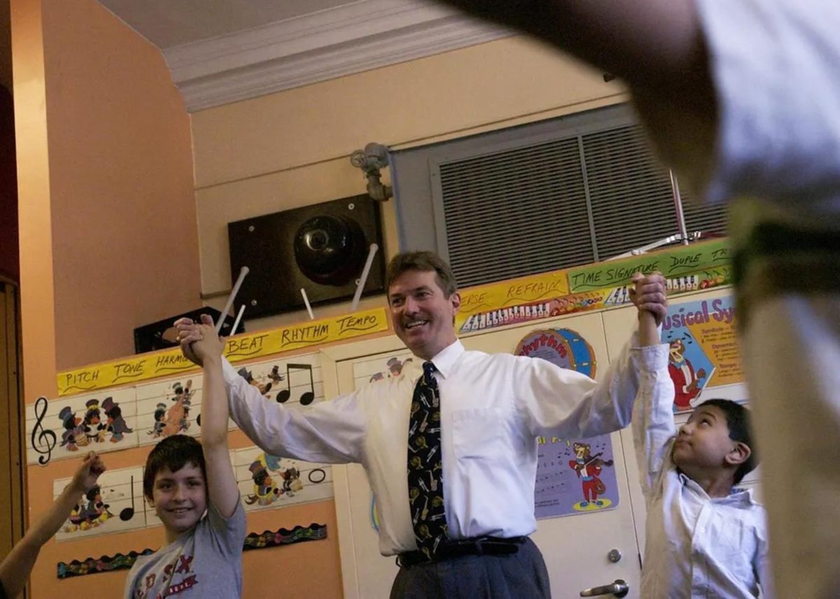 Music teacher Mr. Christopher Grammer joyously teaches young students. (Source: Wicked Local)