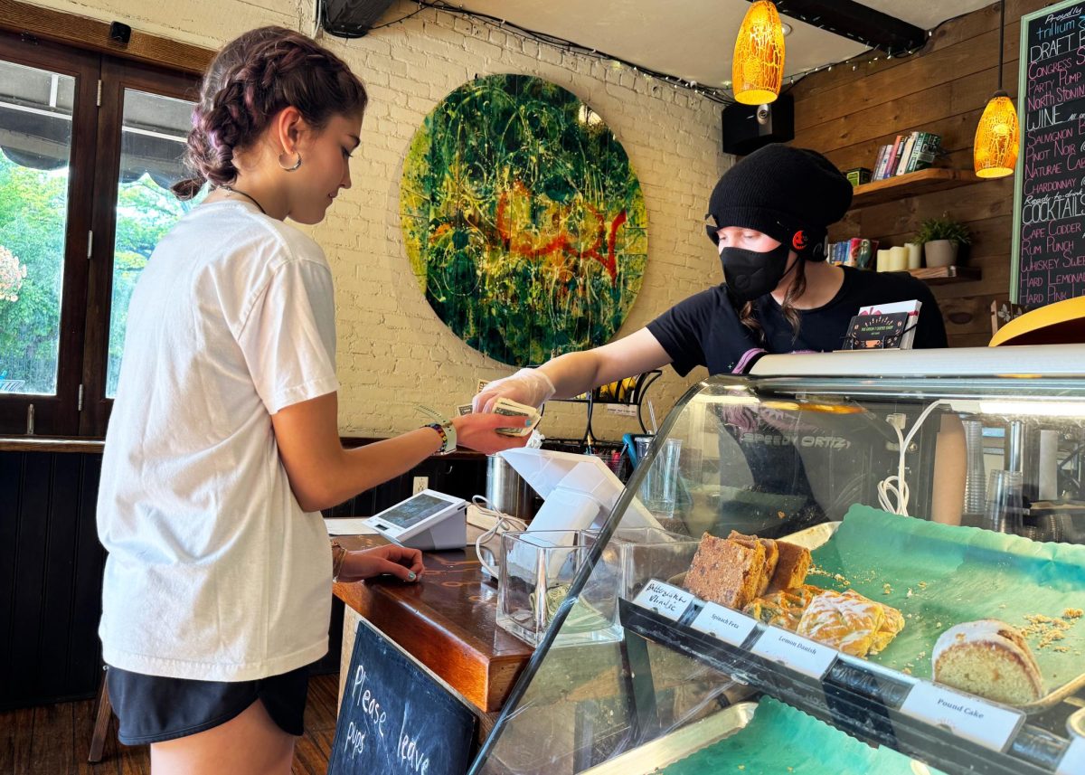 Scarlett Scharfenberg (IV) pays for food at a cafe. (Source: Abby Wilson (IV))