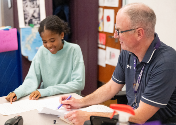 BLS history teacher Mr. David Long helps a student with their assignments. (Source: Kaiya Platt (IV))